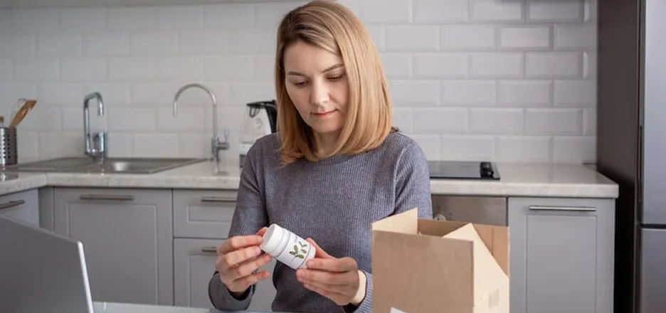 Woman unpacking a medication delivery at home